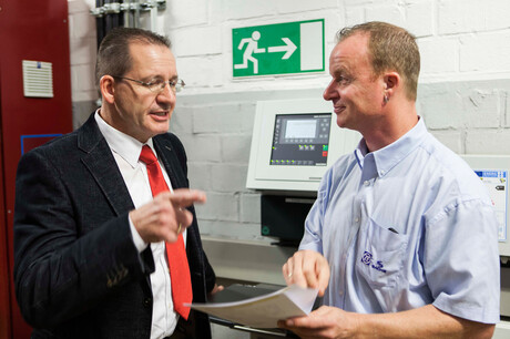 Инженерът на Kaeser Kompressoren Хагес и служителят на ZF Friedrichshafen Баумгартен говорят за плановете на компресорната станция